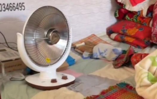 村干部送來的電暖器直接放在被褥上，存在火災隱患